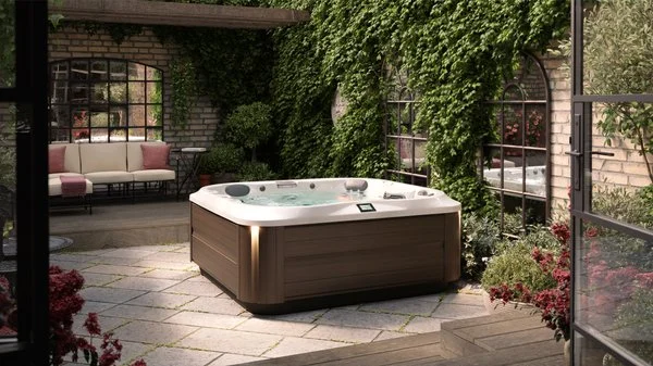 Jacuzzi J-335 hot tub with a white shell and modern hardwood cabinet on a landscaped patio